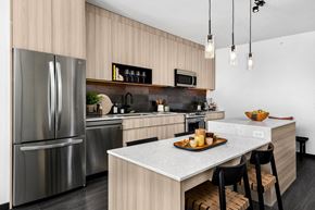 Chicago apartment for rent - A modern kitchen with a stainless steel refrigerator and a marble countertop.