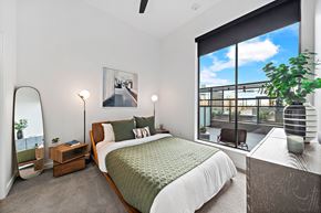 Houston apartment for rent - A bedroom with a large bed and a view of the city.