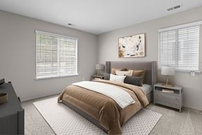 Ann Arbor apartment for rent - A bedroom with a large bed and a nightstand with a lamp.