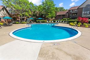 Southfield apartment for rent - A round blue swimming pool surrounded by a concrete patio and a white border.