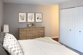 Naperville apartment for rent - A bedroom with a bed, dresser, and three framed pictures on the wall.