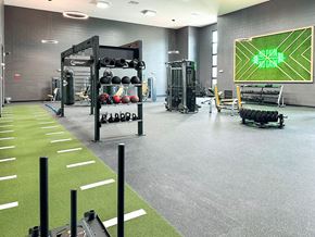 Bradenton apartment for rent - a gym with weights and a scoreboard on the wall