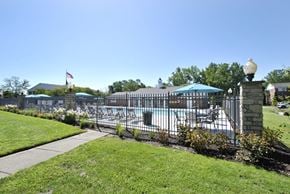 Romulus apartment for rent - walkway to a fenced-in swimming pool at The Maxwell in Romulus, MI
