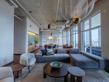 Chicago apartment for rent - A modern living room with a large grey couch and a wooden coffee table.