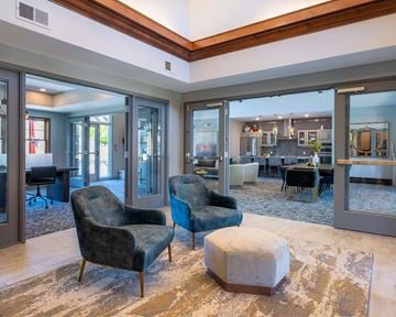 Woodbury apartment for rent - A living room with a blue chair and a white ottoman.