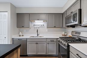 Buffalo Grove apartment for rent - an empty kitchen with stainless steel appliances and gray cabinets