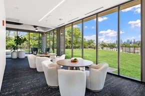 Chicago apartment for rent - plush white chairs around tables next to floor to ceiling windows