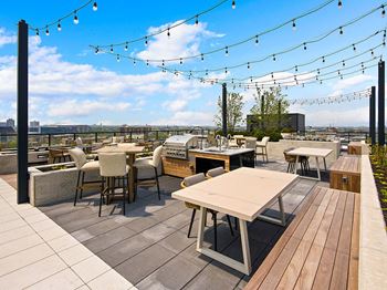 Rooftop courtyard with lounge seating, grills, and fire feature