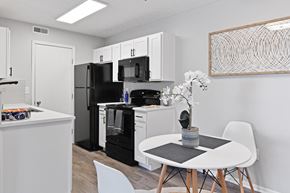 Columbus apartment for rent - a kitchen with a white table and a black refrigerator