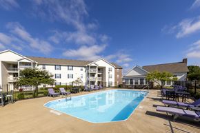 Columbus apartment for rent - A swimming pool surrounded by lounge chairs and apartment buildings.