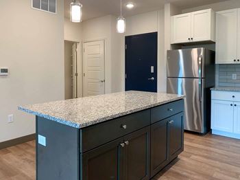 Kitchen with large island, granite counter and a stainless steel refrigerator - marble 207