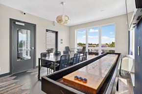 Minneapolis apartment for rent - A shiny pool table is in the middle of a room with a glass door.