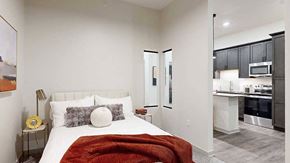 Lincoln apartment for rent - a bed with a red throw blanket and neutral-toned walls