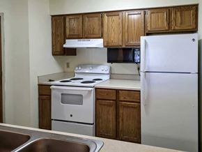 Lincoln apartment for rent - A kitchen with wooden cabinets, white appliances, and a mounted microwave.