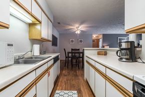 Omaha apartment for rent - A kitchen with white cabinets and a wooden floor.
