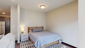 Lincoln apartment for rent - a studio with a bed and bedside table with lamp
