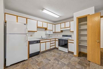 Lincoln apartment for rent - A kitchen with white appliances and wooden cabinets.