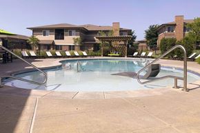 Lincoln townhouse for rent - a swimming pool with chairs around it and a building in the background
