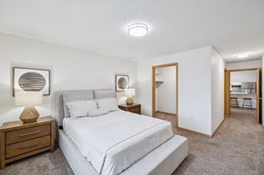 Lincoln apartment for rent - A bedroom with a large bed and two nightstand with lamps, and attached walk-in closet