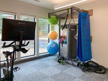Spin and yoga room with punching bag and echelon spin bike