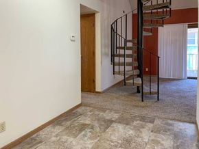 Lincoln apartment for rent - a kitchen that connects to a living room with a spiral metal staircase