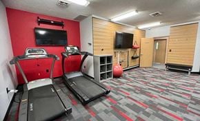 Lincoln apartment for rent - a 24-hour fitness center with treadmills, TVs, and yoga equipment.