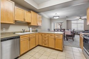 La Vista townhouse for rent - Open apartment kitchen with light wood cabinets, tile flooring, ample counter space, and adjacent dining area.