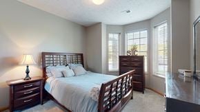 Omaha townhouse for rent - a bedroom with a bed and a dresser brightened with natural light from windows