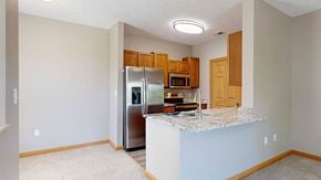 Omaha townhouse for rent - a kitchen with a granite counter top and a stainless steel refrigerator