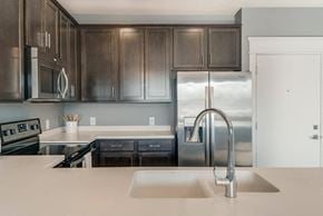 Omaha apartment for rent - A modern kitchen with dark brown cabinets and stainless steel appliances.