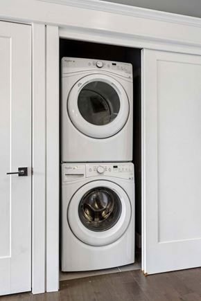 Omaha apartment for rent - Stacked washer and dryer fit neatly into a recessed apartment laundry closet with white sliding doors and trim.