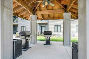 Lincoln apartment for rent - a covered outdoor grill station with two grills and a ceiling fan