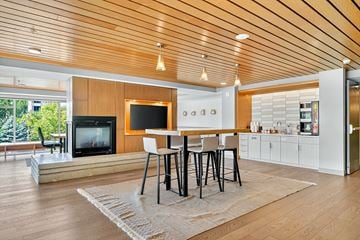 Bloomington apartment for rent - A modern living room with a wooden ceiling and a television on the wall.