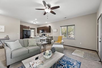 Lincoln townhouse for rent - A living room with a grey couch and a ceiling fan.