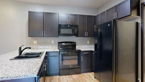 Omaha townhouse for rent - a kitchen with dark cabinets and granite countertops