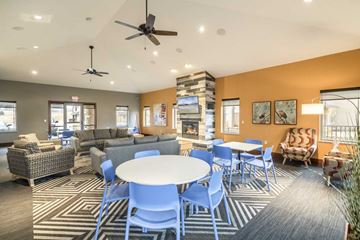 Omaha townhouse for rent - a clubhouse with tables and chairs and a living room
