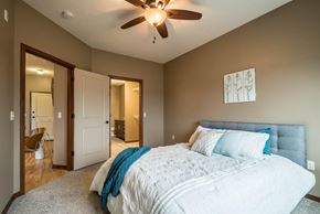 Omaha townhouse for rent - A bedroom with a large bed and a ceiling fan.