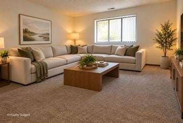 Lincoln apartment for rent - A living room with a large couch, a coffee table, and a painting on the wall.