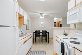Lincoln apartment for rent - a kitchen with white appliances and a dining room table with chairs in the back