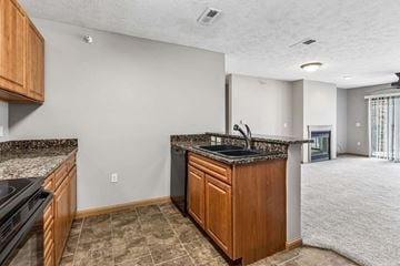 Omaha triplex for rent - A kitchen with a black countertop and wooden cabinets.