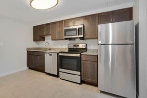 Frederick apartment for rent - a kitchen with wooden cabinets and stainless steel appliances