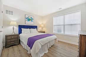 Clarksburg apartment for rent - A bedroom with a bed, nightstand, and lamp.