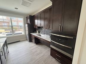 Prince Frederick apartment for rent - A kitchen with dark wood cabinets and a black oven.