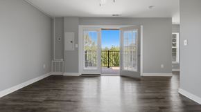 Lexington Park apartment for rent - A large empty room with a view of a fence and trees outside.