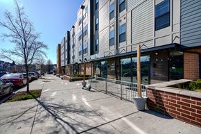 Baltimore apartment for rent - A modern building with a parking lot in front.