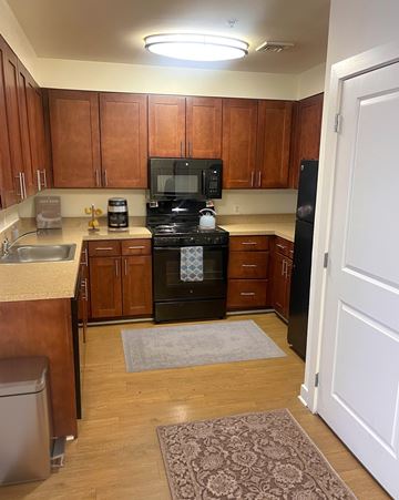 Odenton apartment for rent - A kitchen with wooden cabinets and a black stove top oven.