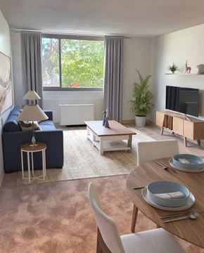 Rockville apartment for rent - A modern living room with a blue sofa, wooden coffee table, and a television.