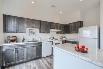 Baltimore apartment for rent - A kitchen with a white fridge and a marble counter top.