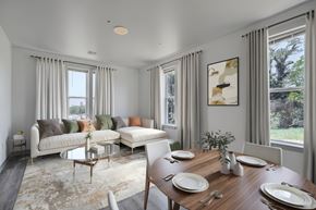 Baltimore apartment for rent - A dining room with a table set for two and a couch with pillows.