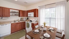 Frederick townhouse for rent - a kitchen and dining room with wooden cabinets and a table